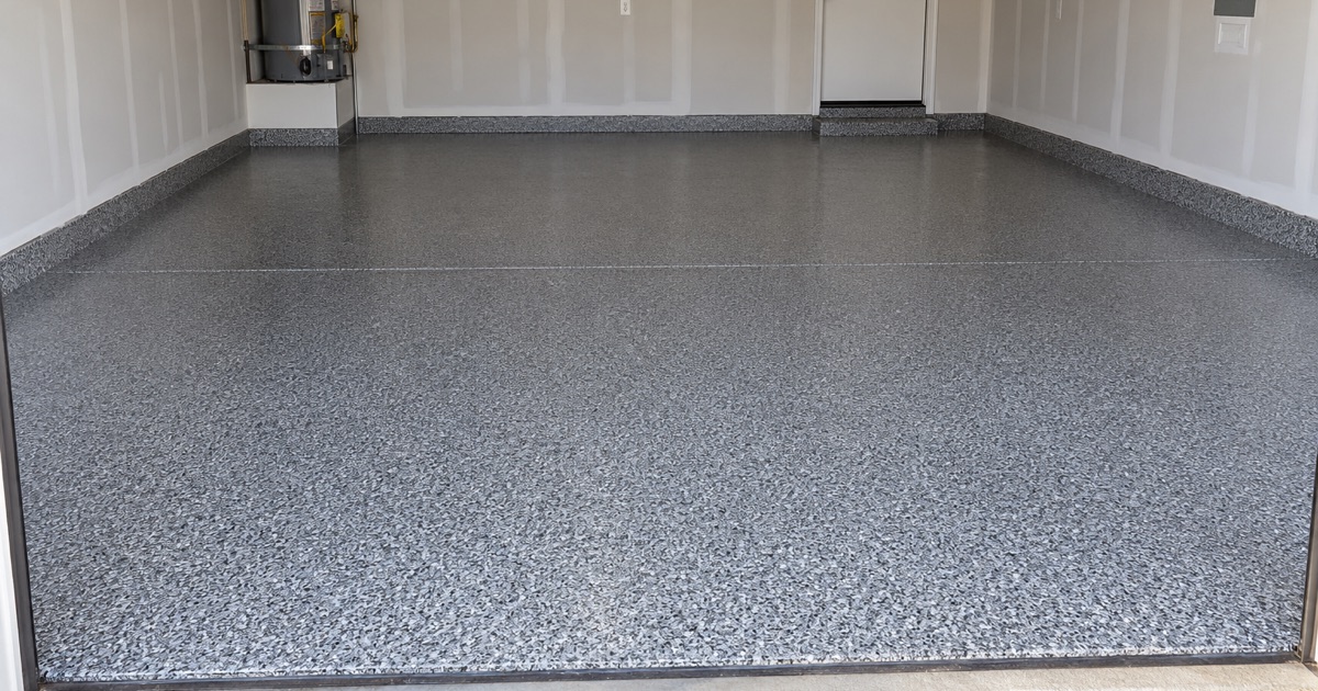 An empty garage with a finished gray flake floor.